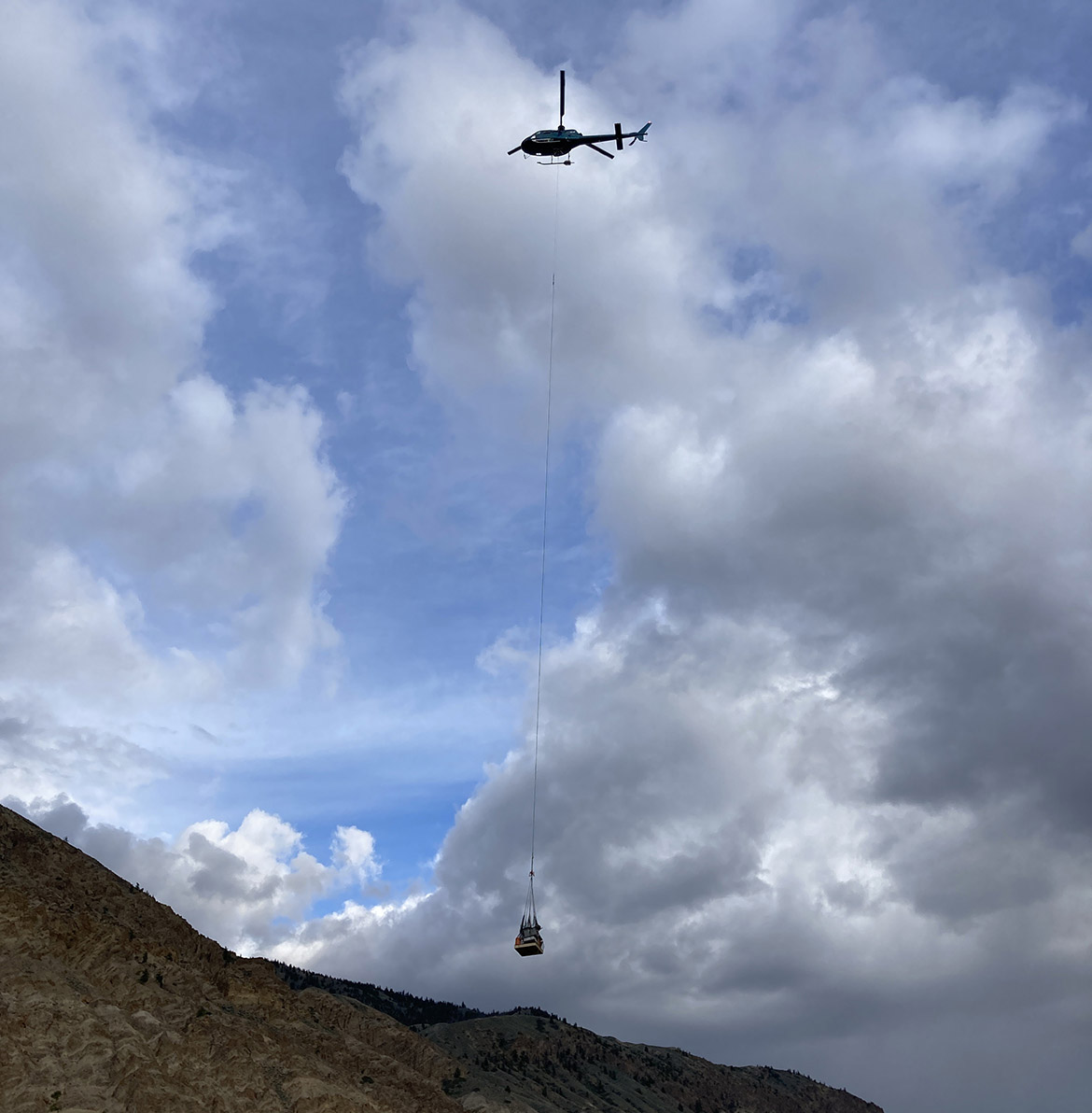 A helicopter delivers cameras, sensors and cables for installation along the west face of the cliff.